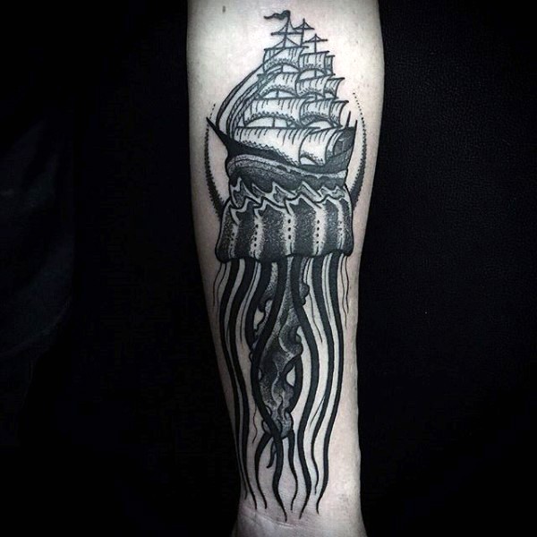 Big black and white jellyfish with old ship tattoo on arm