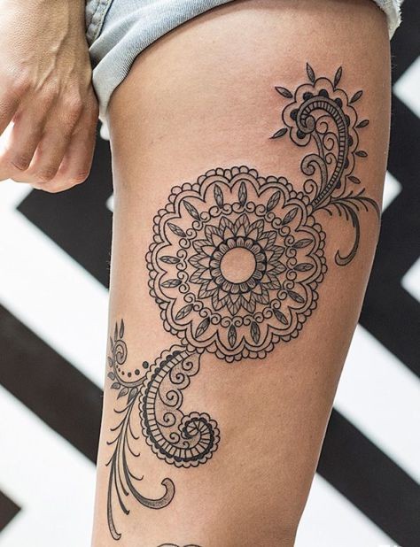 Big black and white tribal style flower with ornaments tattoo on thigh