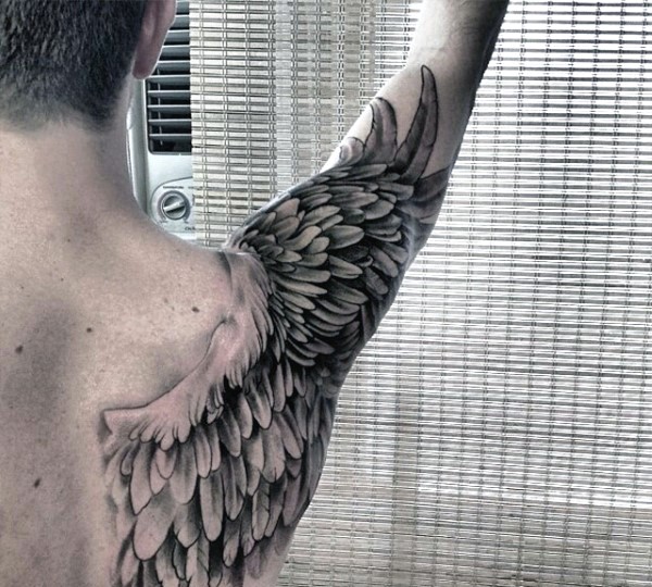 Una ala grande realizada en negro y blanco tatuaje en el antebrazo