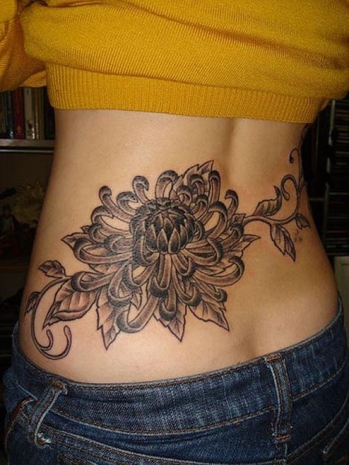 Big black flower tattoo on lower back