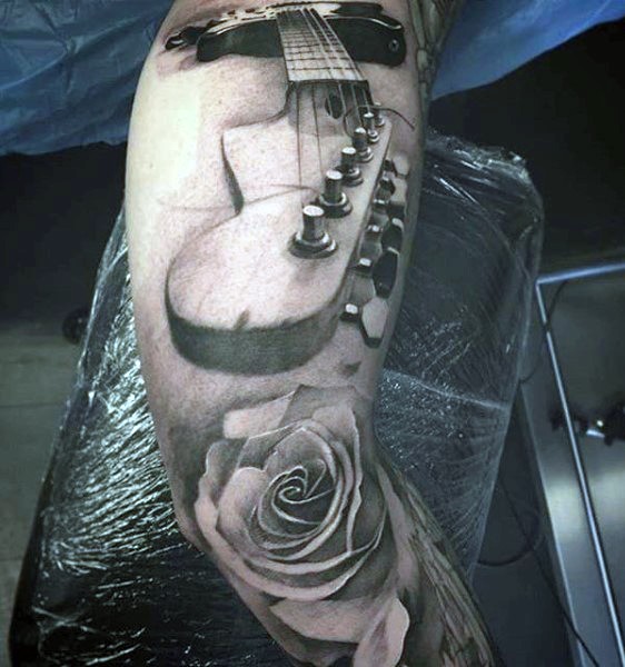 Tatuaje negro blanco en el brazo, parte de guitarra grande 3D con rosa delicada