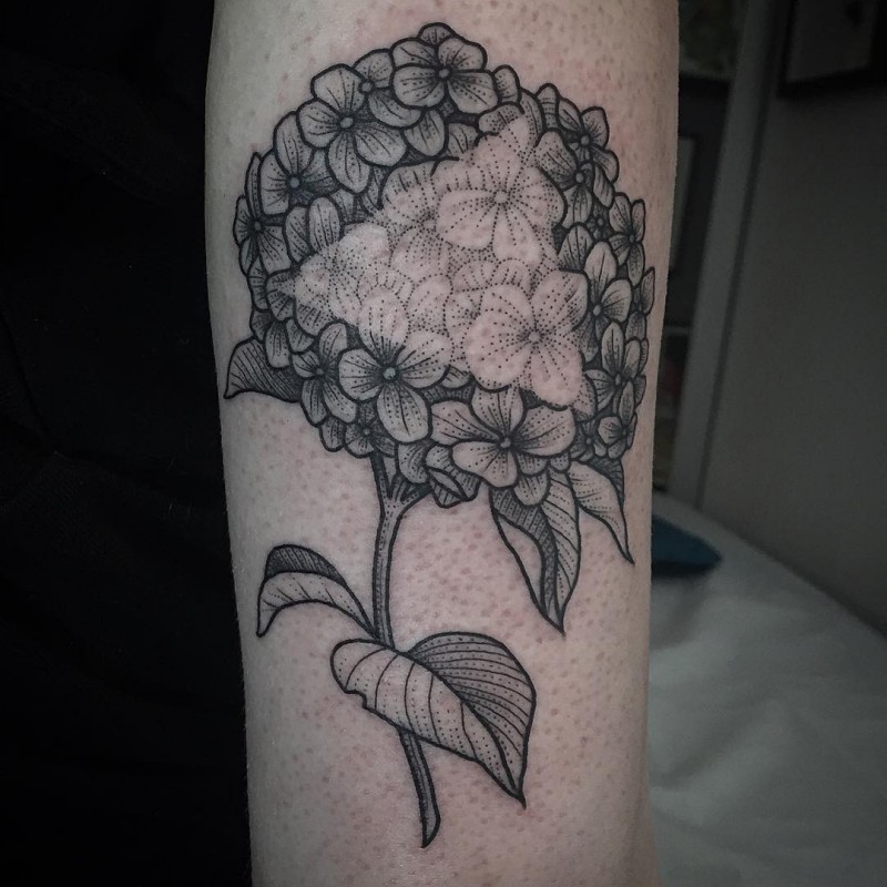 Big black ink beautiful painted flower tattoo on arm stylized with white triangle