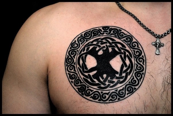 Big black ink Celtic style circle tattoo on chest stylized with tree