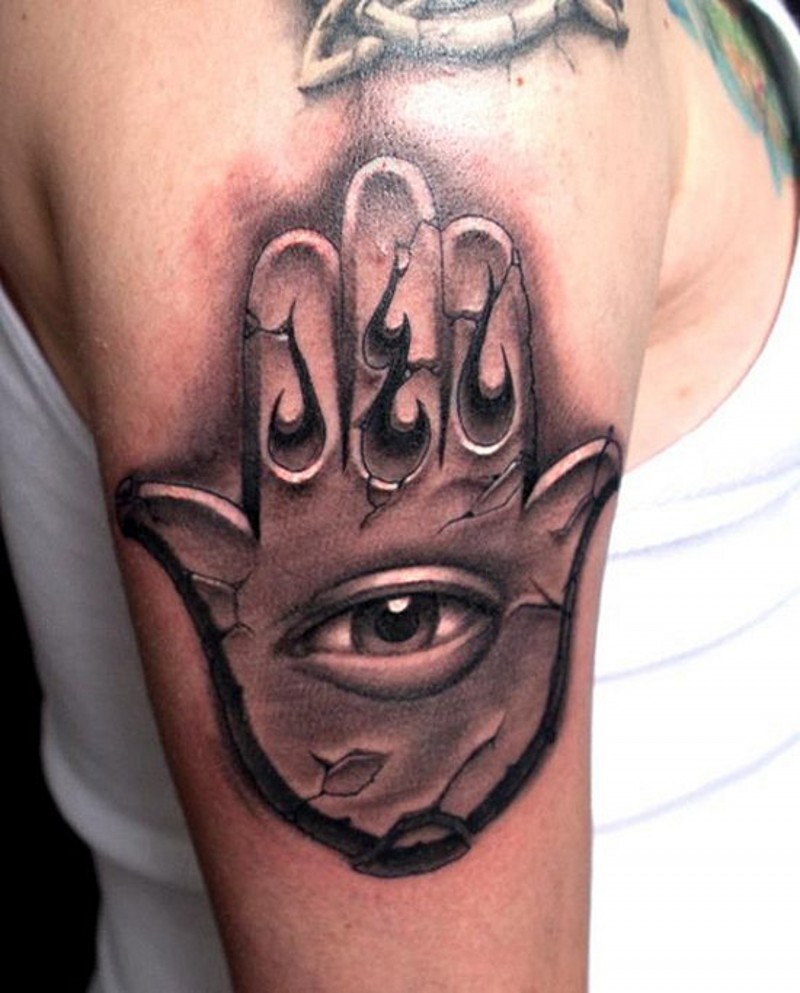 Big black ink cult style mystical hand with eye tattoo on top of the arm