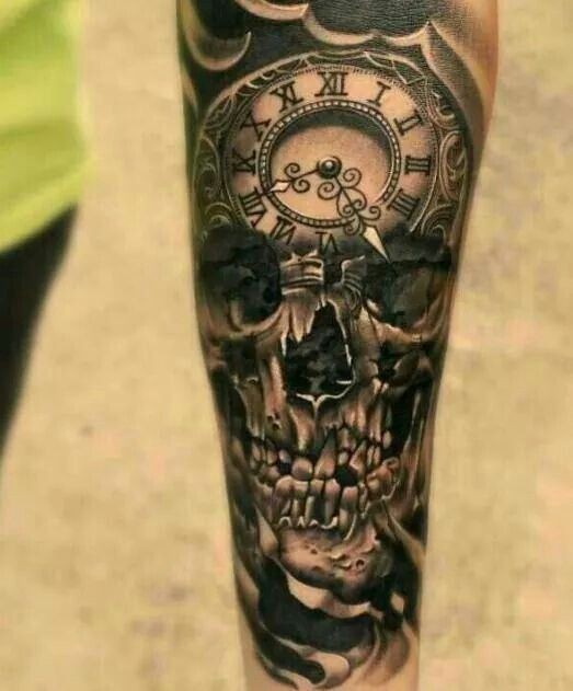 Großer schwarzer detaillierter Schädel Tattoo am Unterarm mit alter Uhr