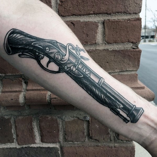 Big black ink forearm tattoo of antic pistol and lettering