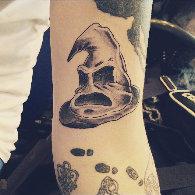 Tatuaje en el brazo, sombrero seleccionador enfadado de colores negro blanco