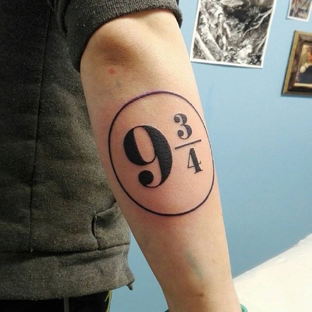 Big black ink numbers tattoo on forearm stylized with circle