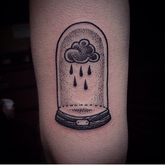 Tatuaje en el brazo,
nube de lluvia bajo el vidrio