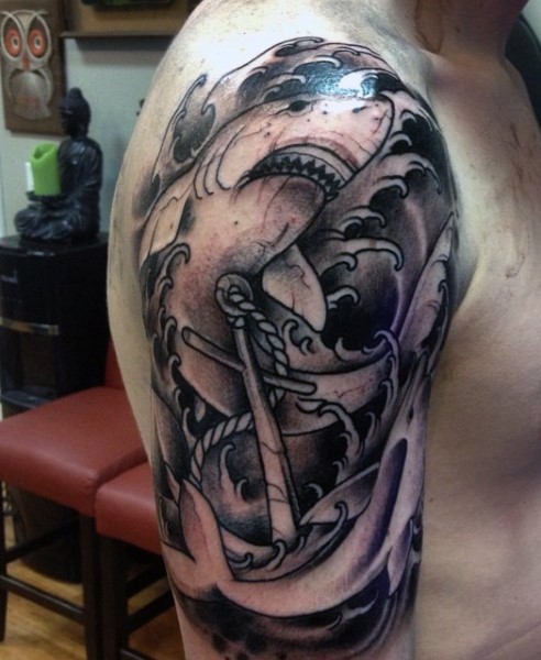 Big black ink shark tattoo on shoulder combined with roped anchor
