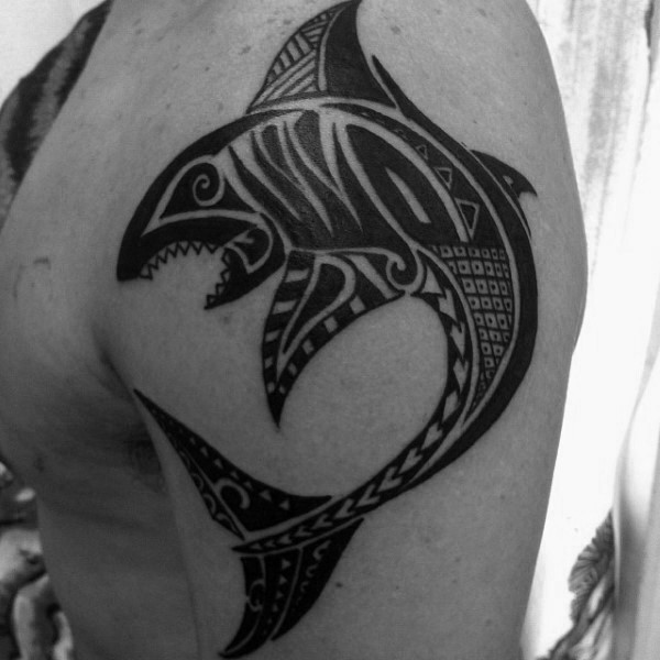 Big black ink shoulder tattoo of shark stylized with Polynesian ornaments