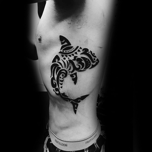 Big black ink side tattoo of shark stylized with various Polynesian ornaments