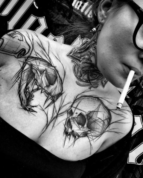 Big black ink sketch like chest tattoo of animal and human skulls