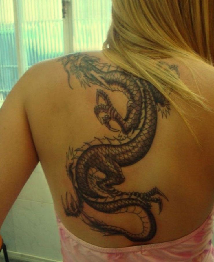 Tatuaje en la espalda, dragón negro con el cuerpo largo