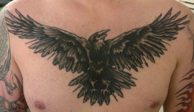 Tatuaje en el pecho, cuervo siniestro con alas desplegadas
