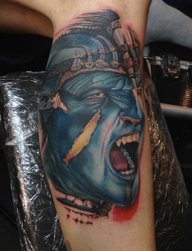 Tatuaje colorido en el brazo, cabeza de Avatar gritando