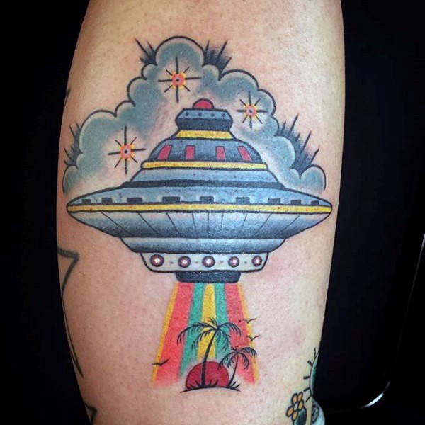 Big colored cartoon alien ship with island tattoo on leg