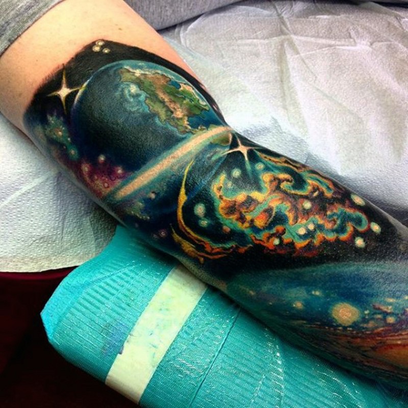 Tatuaje en el brazo, cosmos con la Tierra espectacular