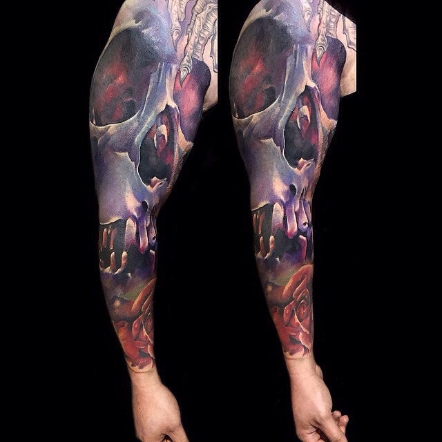 Big colored unusual colored human skull tattoo on sleeve with rose flower
