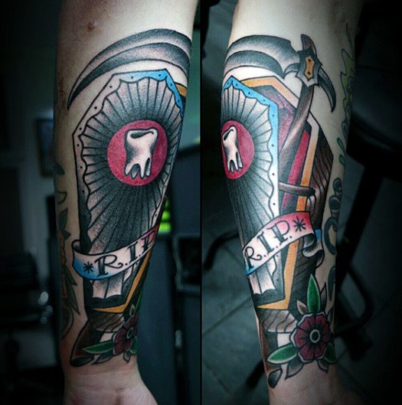 Big colorful coffin with lettering and tooth tattoo on wrist