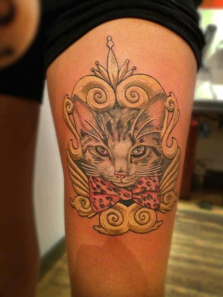 Big cute colored cat with bow portrait tattoo on thigh