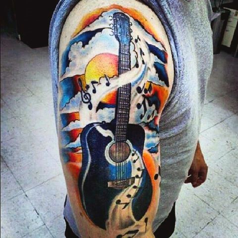 Big great colored acoustic guitar with notes shoulder tattoo