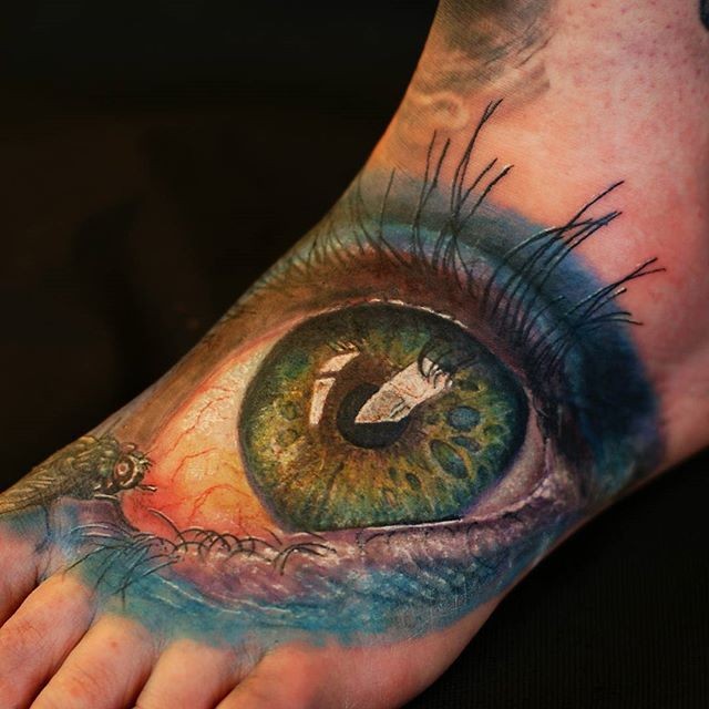 Big green eye tattoo on foot by Cris Gherman