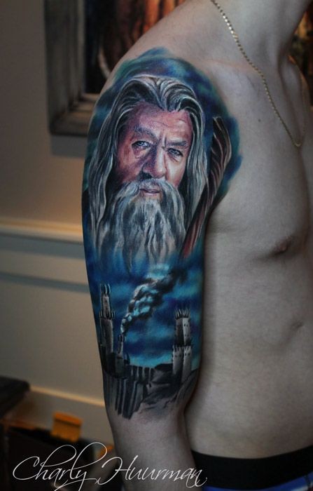 Big illustrative style colored shoulder tattoo of Gandalf wizard and towers