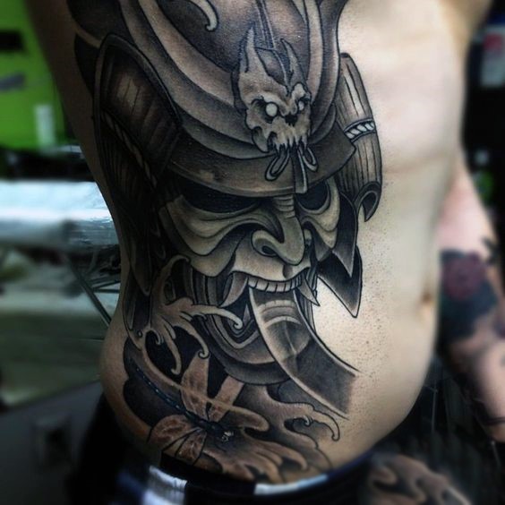 Big marvelous detailed colored samurai mask tattoo on side with dragonfly