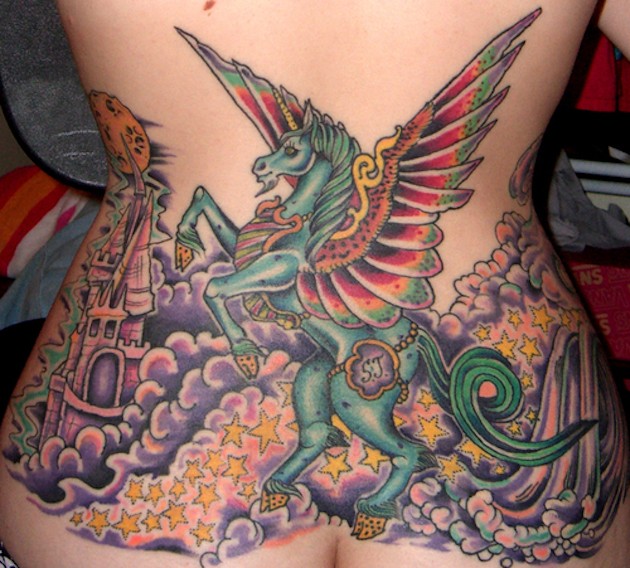 Tatuaje  multicolor en la espalda baja, unicornio fantástico con castillo y montón de estrellas