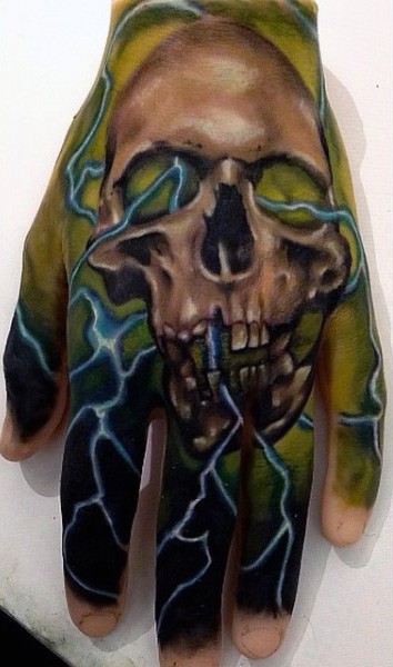 Big multicolored skull in mystic fog tattoo on hand