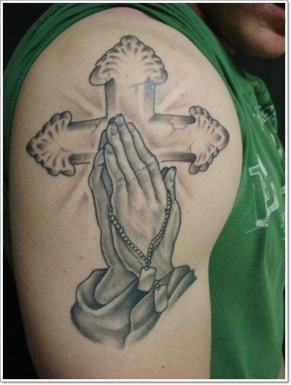 Tatuaje en el brazo,
manos que oran y cruz, diseño de colores negro y blanco