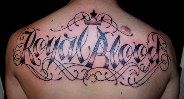 Großes schön gemaltes schwarzes Tattoo am oberen Rücken mit Schriftzug &quotRoyal Blut"