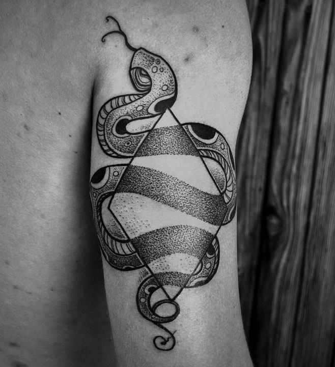 Big old school black and white snake tattoo on arm stylized with geometrical figure