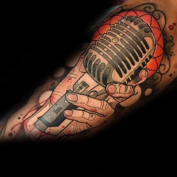 Tatuaje en el brazo, mano que lleva el micrófono