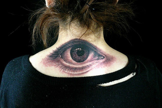 Big realistic eye tattoo on lower neck for girls