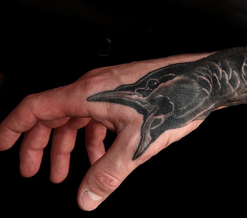 Tatuaje en la mano,  cuervo amenazante que grita