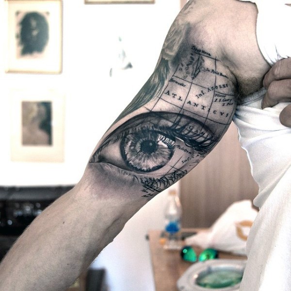 Tatuaje en el brazo, ojo grande imprecionante y mapa del mundo
