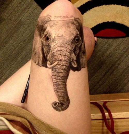 Big realistic painted black and white elephant head with lettering tattoo on thigh