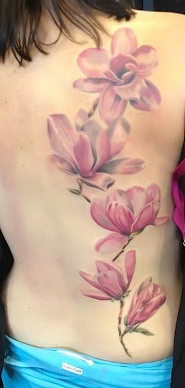 Big size delicate and tender pale pink detailed realistic flowers tattoo on woman's back