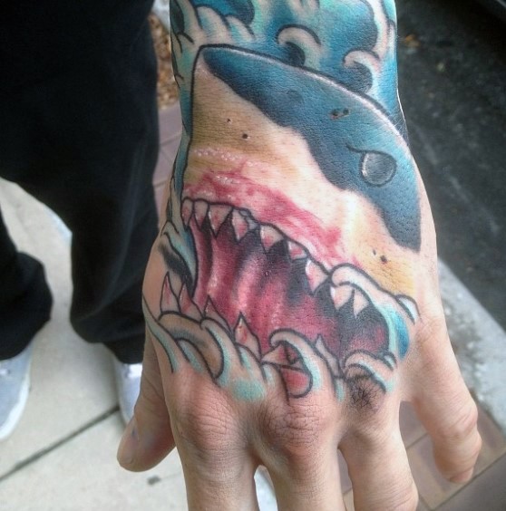 Big size shark's head with open mouth colored tattoo on hand in old school style