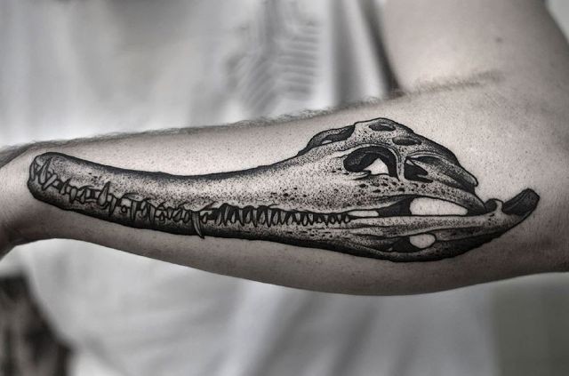 Big stippling style black ink forearm tattoo of alligator skull