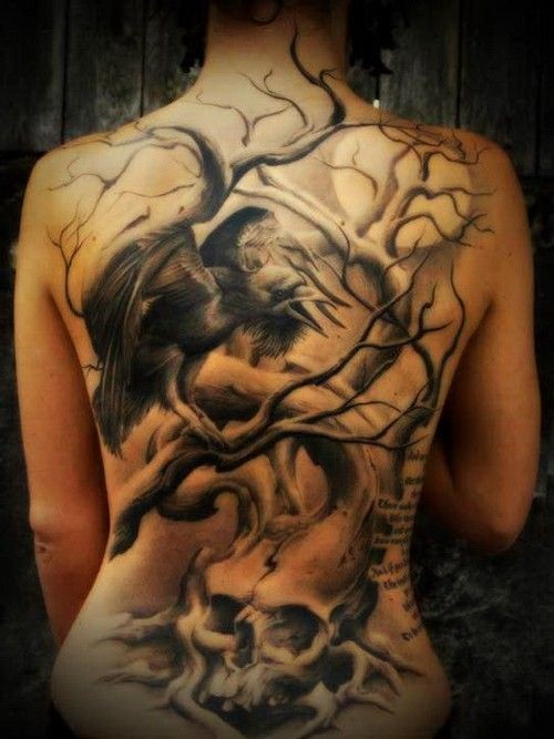 Tatuaje en la espalda de un árbol que crece en una calavera con cuervos.