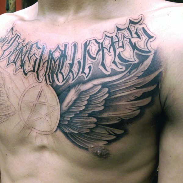 Big unfinished mystical tattoo with lettering and wings on chest