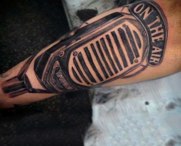 Big very detailed black ink vintage microphone with lettering tattoo on arm