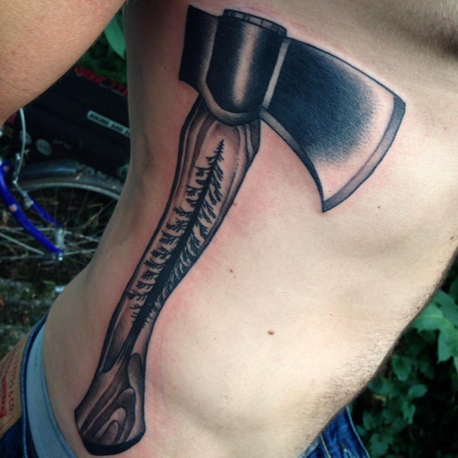 Big wooden ax decorated with pine tree detailed side tattoo