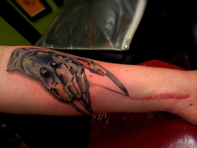 Biomechanical hand with long sharp steel clutches colored 3D realistic style tattoo