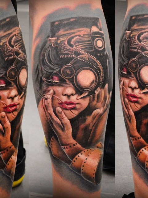 Biomechanical style colored leg tattoo of woman face with strange camera