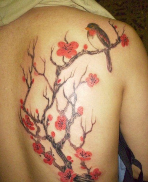 Tatuaggio colorato sulla schiena l&quotuccello sul ramo fiorito