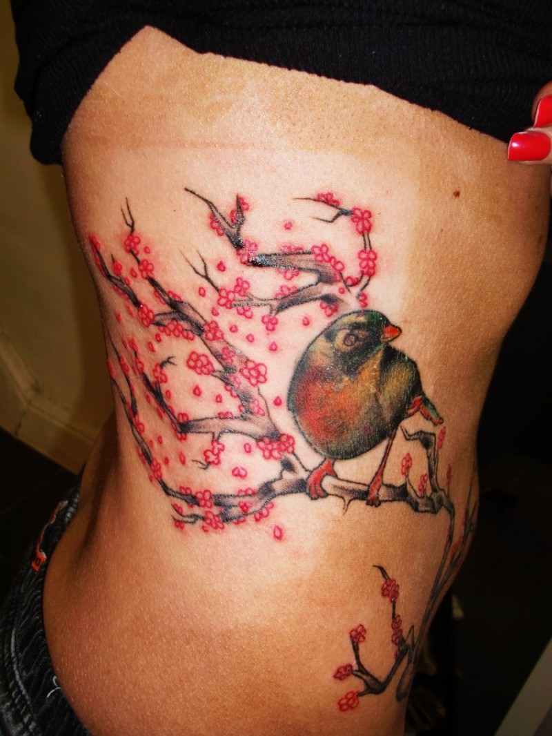Tatuaggio sul fianco l&quotuccello sul ramo fiorito